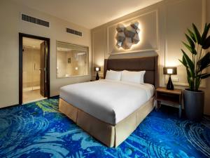 a bedroom with a large bed and a bathroom at Eastin Hotel Penang in Bayan Lepas