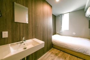 a bathroom with a sink and a bed in it at &AND HOSTEL ASAKUSA KAPPABASHI in Tokyo