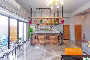 a kitchen and living room with a bar with stools at Huayu Homestay in Magong