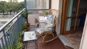 a rocking chair on a balcony with a table at A Firenze da Paolo in Florence