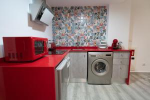una cucina con piano di lavoro rosso e lavatrice di ROMANTICA a Anna
