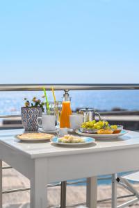 uma mesa branca com pratos de comida em Veranta Luxury Suite em Chora Sfakion