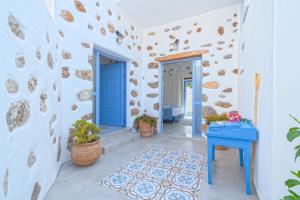 Veranta Luxury Suite في خورا سفاكيون: منزل بأبواب زرقاء وطاولة زرقاء