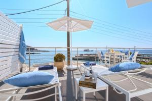 Veranta Luxury Suite في خورا سفاكيون: شرفة مع كراسي وطاولة وإطلالة على المحيط