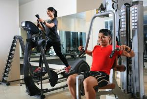 a man and a woman in the gym at Swiss-Belhotel Makassar in Makassar