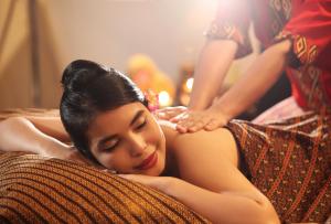 a woman laying on a couch with her head on a pillow at Swiss-Belhotel Makassar in Makassar