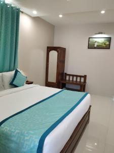 a bedroom with a large bed and a chair at Hotel The Lighthouse in Jaipur