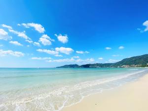 a beach with a blue sky and the ocean at Burasari Phuket Resort & Spa - SHA Extra Plus in Patong Beach