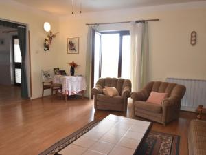 a living room with two chairs and a table at Comfortable holiday home in Labin in Drenje