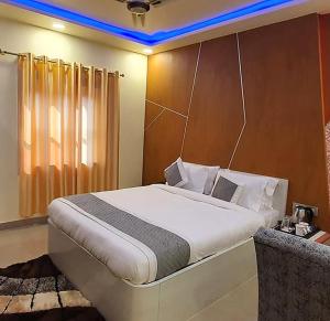 um quarto com uma grande cama branca num quarto em Gokul Raj By WB Economy , Madhubani em Madhubani