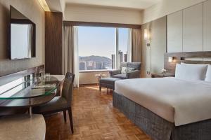 a hotel room with two beds and a table at Nina Hotel Tsuen Wan West in Hong Kong