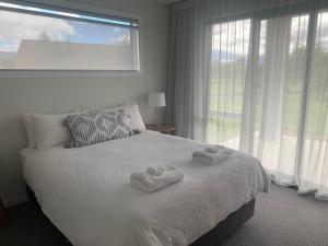 een slaapkamer met een bed met twee handdoeken erop bij ValleyView Wanaka in Wanaka