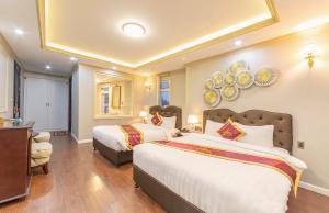 Postel nebo postele na pokoji v ubytování Queen T&T Dalat Hotel