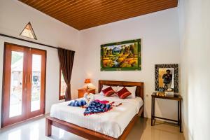 Alam Selumbung Garden في نوسا بينيدا: غرفة نوم مع سرير مع دمية ملقاة عليه
