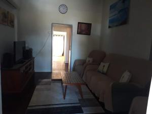 a living room with a couch and a clock on the wall at 66a farnborough rd in Yeppoon