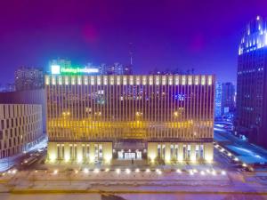 a large building in a city at night at Holiday Inn Express Harbin Qunli, an IHG Hotel in Harbin