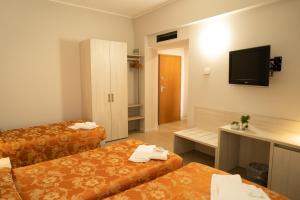 a hotel room with two beds and a flat screen tv at Hotel Europa in Dossobuono