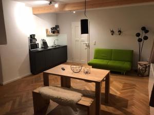 ein Wohnzimmer mit einem grünen Sofa und einem Tisch in der Unterkunft WAGNERS Ferienwohnungen in Norhalben in Nordhalben