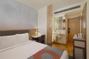 a hotel room with a bed and a bathroom at Holiday Inn Express Bengaluru Yeshwantpur, an IHG Hotel in Bangalore