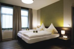 a bedroom with a large white bed and two windows at Konsumhotel am Park in Oberhof +84 photos