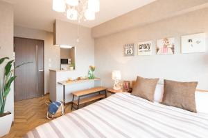 1 dormitorio con 1 cama grande y escritorio en @RLiS_house大阪ドームシティ en Osaka