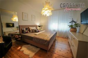 una camera da letto con un letto e un lampadario di CROSSHILL Appartements - Charmante und helle Wohnung a Schwandorf
