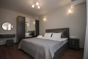 Hillside Guest House في يريفان: غرفة نوم بسرير كبير ومرآة