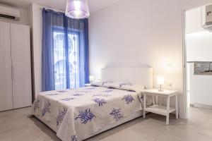 a white bedroom with a bed and a window at Marina in Brolo