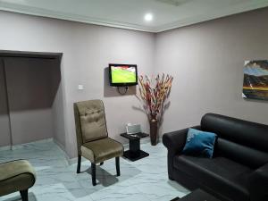 sala de estar con sofá y TV en ULOM 1condos apartment, en Owerri