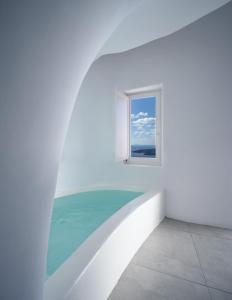 a white room with a window and water at Panorama Boutique Hotel in Fira