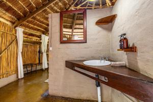 a bathroom with a sink and a mirror at Umlani Bushcamp in Timbavati Game Reserve