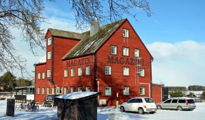 a large red brick building with cars parked in front of it at Gotland Magazin1 Guesthouse in Havdhem