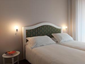 a bedroom with a bed with two pillows and a table at Trilocale Ferruccio in Baveno