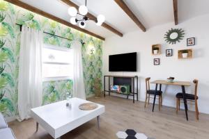 a living room with a tv and a table at Home2Book Vintage American Deluxe La Laguna in Las Lagunas