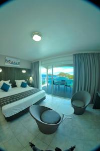 a bedroom with a bed and a view of the ocean at Hôtel Bois Joli in Terre-de-Haut