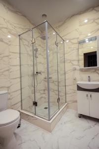 a bathroom with a shower with a toilet and a sink at Hillside Guest House in Yerevan
