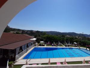a swimming pool with a balcony overlooking the ocean at Eleni Apartments in Arillas
