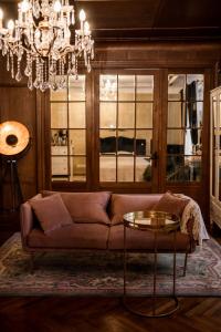 uma sala de estar com um sofá e um lustre em Concert Hall boutique apartment em Cēsis