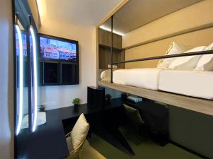a hotel room with a bed and a tv at ST Signature Chinatown in Singapore