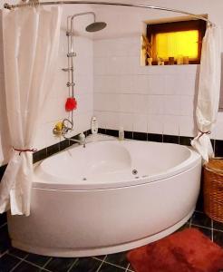 a white bath tub in a bathroom with a window at Guest House Marketti in Vynohradiv