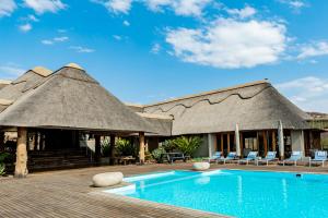 a resort with a pool and chairs and a building at Lions Valley Lodge in Nambiti Private Game Reserve