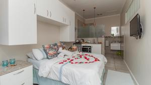 a room with a bed with a cake on it at Sea Breeze Guest House in Bloubergstrand