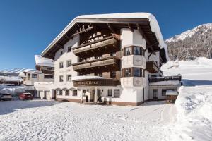 un edificio nella neve con molta neve di Landhaus Strolz a Sankt Anton am Arlberg