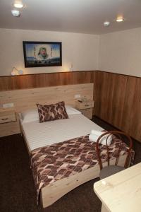 1 dormitorio con 1 cama y TV en la pared en Yurta Mini Hotel, en Ulan-Ude