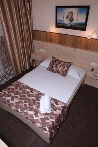 Habitación de hotel con cama y TV en la pared en Yurta Mini Hotel, en Ulan-Ude