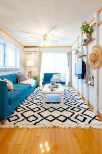 那霸的住宿－Type D Room 40平米 -ウル エスポワール那覇-，客厅配有蓝色的沙发和地毯。