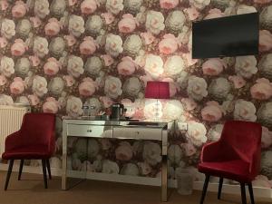 a room with a desk and two chairs and a tv at Le Patio in Évran