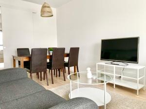 a living room with a couch and a table with a tv at City Home Finland Big Luxury Suite - Spacious Suite with Own SAUNA, One Bedroom and Furnished Balcony next to Train Station in Tampere