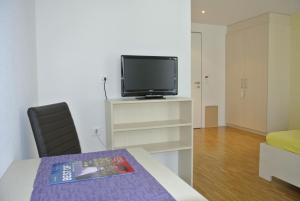 a living room with a tv and a table and chairs at Hotel Garni Bären Bazenheid in Bazenheid