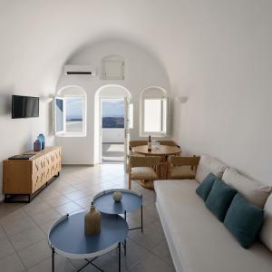 ein Wohnzimmer mit Sofa und Tisch in der Unterkunft Panorama Suites in Fira